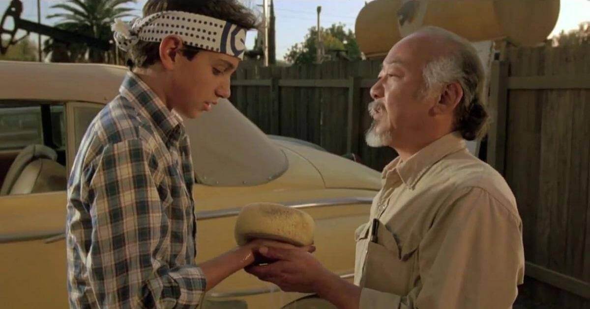 Screen shot from Karate Kid of Daniel-son and Mr. Miyagi. Miyagi is handing Daniel-son the sponge with which to "wax on, wax off". Image is symbolic of self discipline.