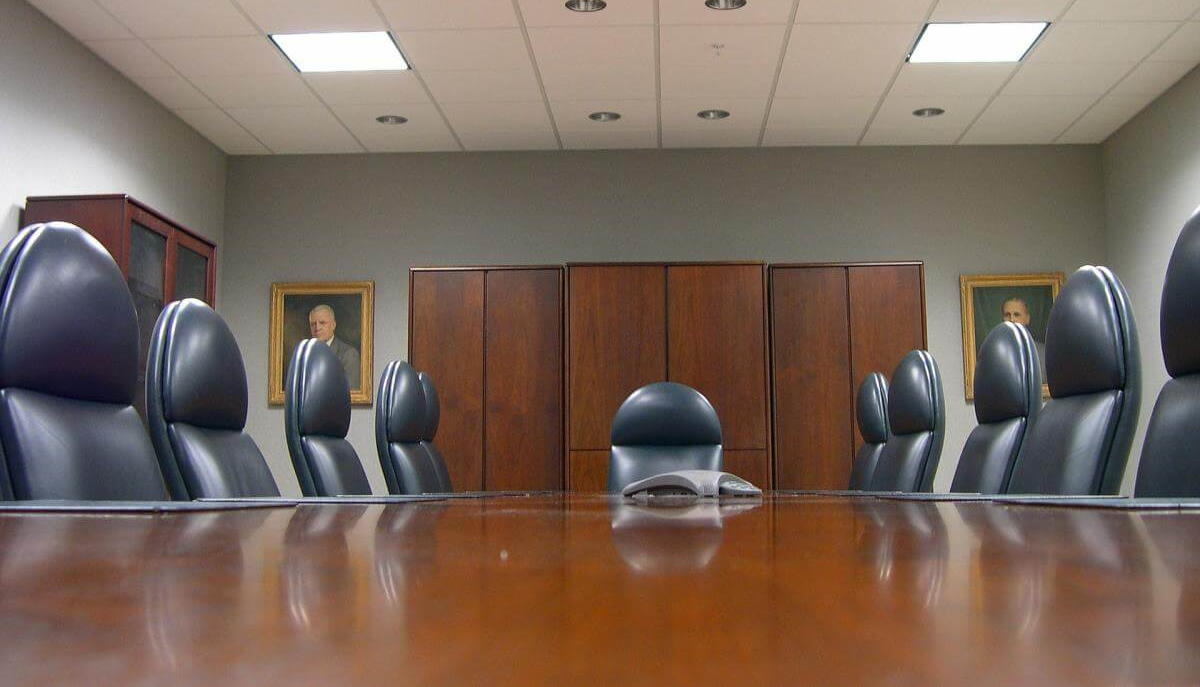 A picture of a typical VC backed company boardroom, complete with long table and a bunch of empty executive chairs.